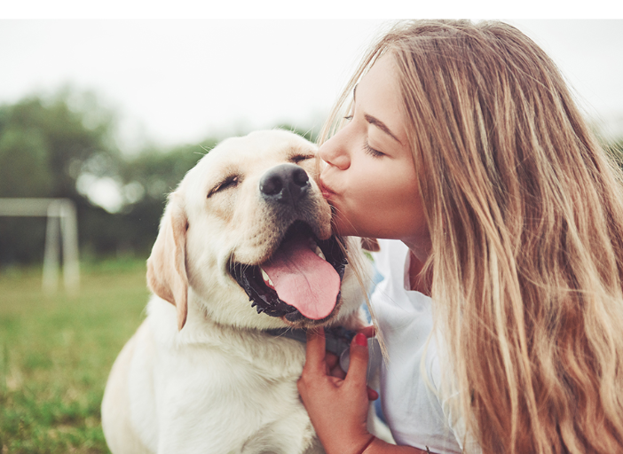 A woman kissing a happy dog